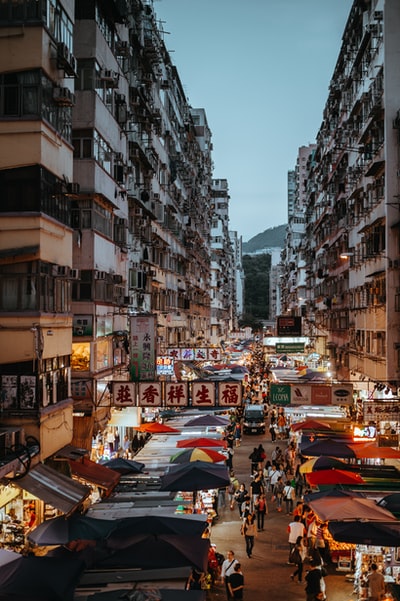 一群人走在混凝土建筑之间的通路
